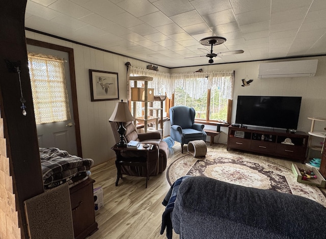 living room with light wood-type flooring and an AC wall unit