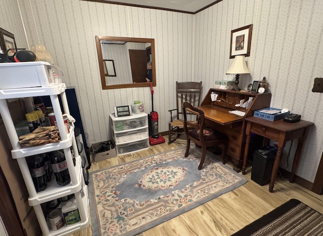 home office featuring wood finished floors, crown molding, and wallpapered walls