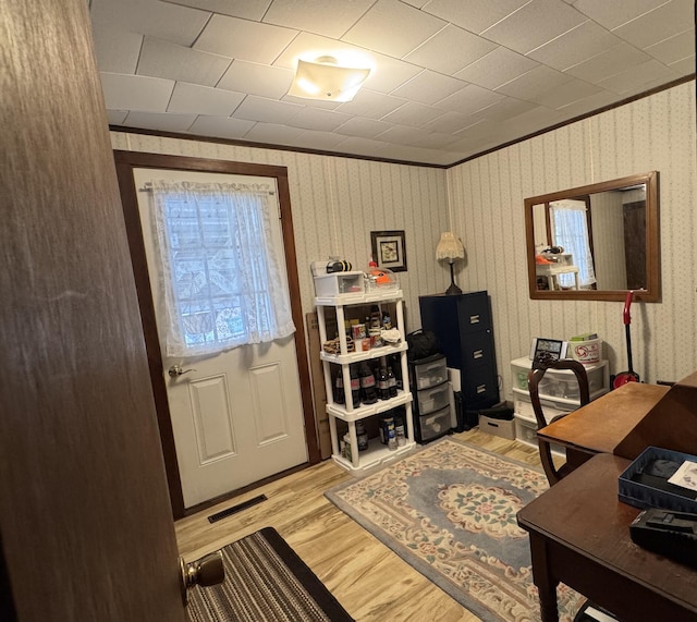 office with ornamental molding, visible vents, and light wood-style flooring