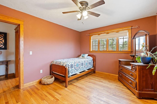 bedroom with a ceiling fan, light wood-style flooring, and baseboards