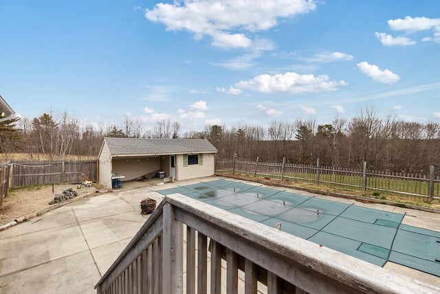 view of swimming pool featuring an outbuilding, a fenced in pool, a fenced backyard, and a patio area