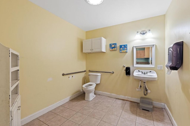 half bathroom featuring tile patterned floors, a sink, toilet, and baseboards