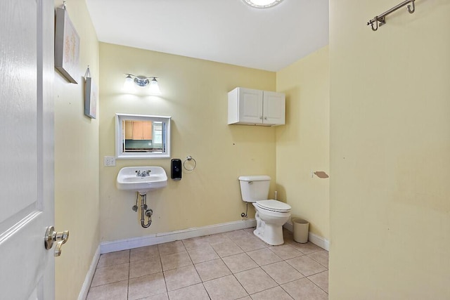 bathroom featuring toilet, tile patterned floors, and baseboards