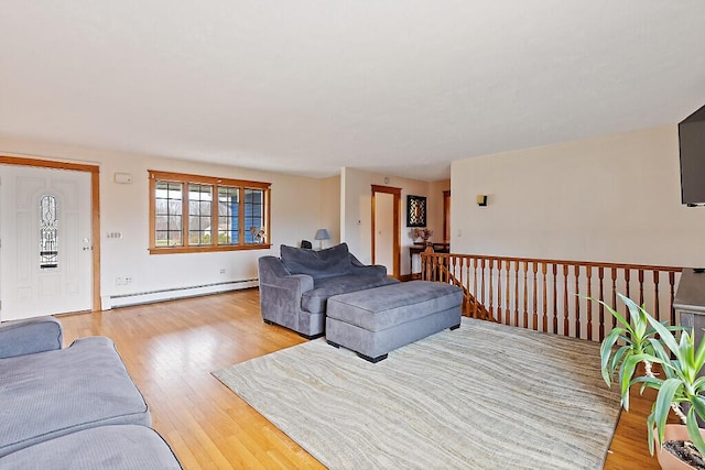 living area with a baseboard heating unit and light wood-style flooring
