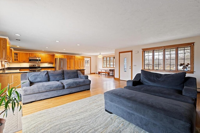 living area with light wood-type flooring and recessed lighting