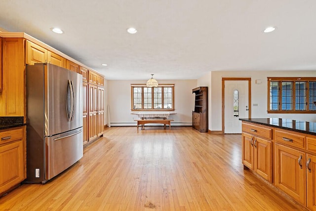 kitchen with recessed lighting, freestanding refrigerator, a baseboard heating unit, dark countertops, and light wood finished floors
