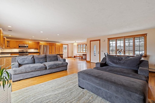 living room with light wood-style floors and recessed lighting