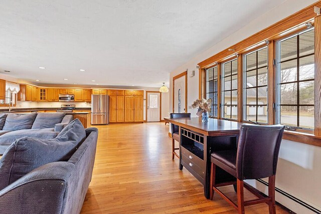 dining room featuring light wood-style floors, recessed lighting, and baseboard heating