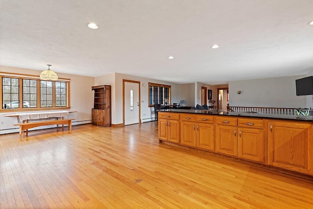 kitchen featuring light wood finished floors, dark countertops, and baseboard heating