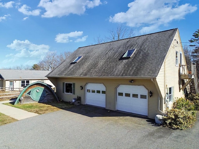 view of front facade featuring roof with shingles, a garage, and aphalt driveway