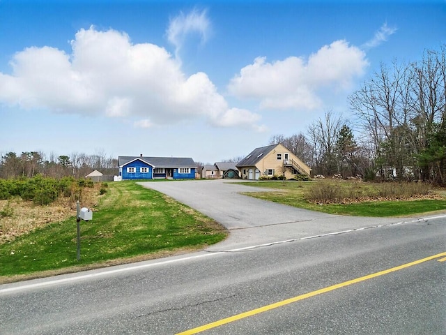 view of front of home with aphalt driveway and a front lawn
