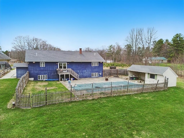 rear view of house with a fenced in pool, a chimney, a patio area, a lawn, and a fenced backyard