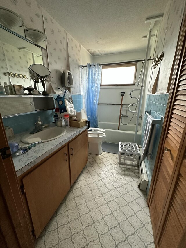 bathroom with wallpapered walls, toilet, vanity, shower / tub combo, and a textured ceiling