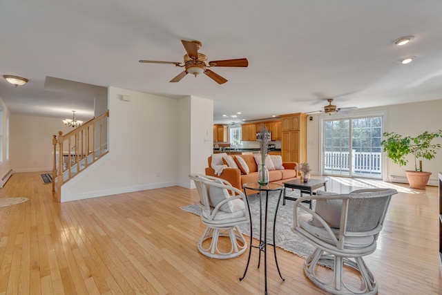 living area with recessed lighting, stairs, ceiling fan with notable chandelier, baseboards, and light wood-type flooring