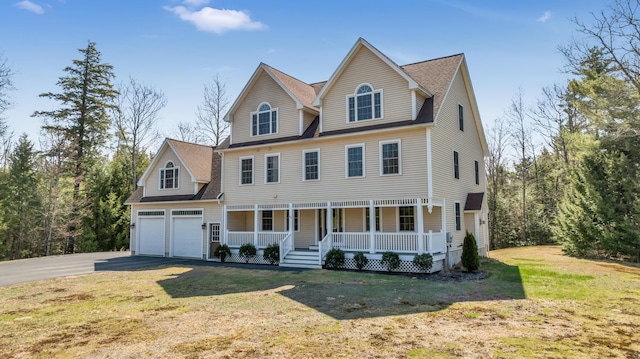 colonial home with aphalt driveway, roof with shingles, covered porch, an attached garage, and a front lawn