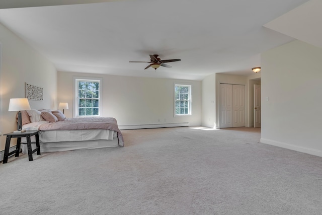 carpeted bedroom featuring baseboards, a ceiling fan, multiple windows, and a baseboard radiator