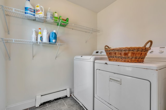 laundry area with laundry area, light tile patterned floors, baseboard heating, washing machine and dryer, and baseboards
