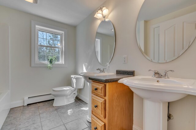 bathroom featuring a sink, a baseboard heating unit, baseboards, toilet, and tile patterned flooring