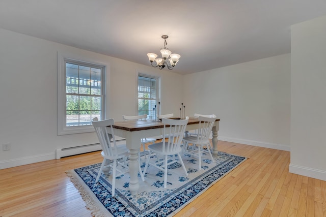 dining room with light wood-style flooring, a notable chandelier, baseboard heating, and baseboards