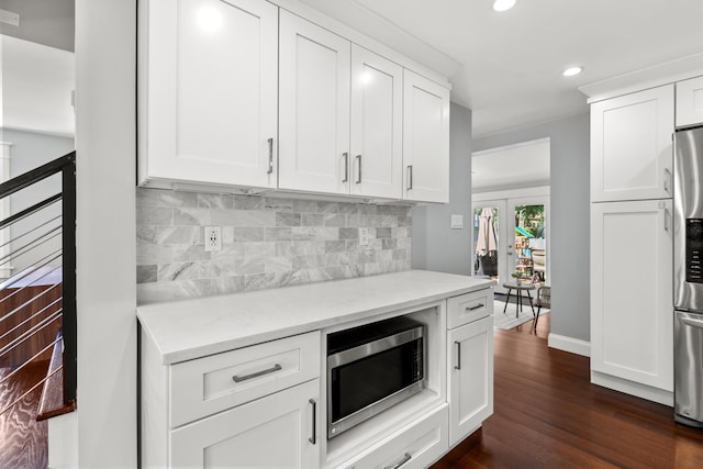 kitchen with recessed lighting, stainless steel appliances, white cabinetry, backsplash, and light countertops