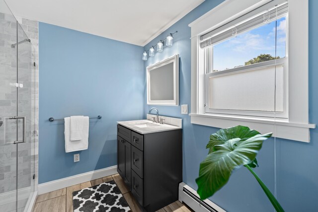 bathroom featuring a stall shower, wood finished floors, vanity, and baseboards