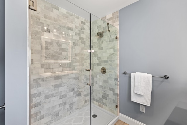 full bath with a shower stall and baseboards