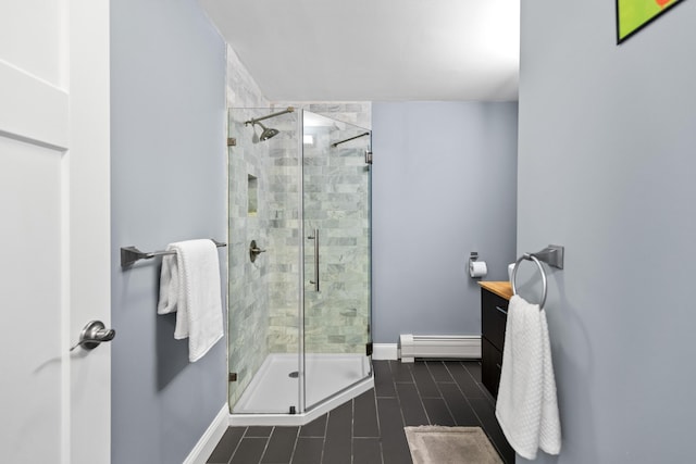 full bath featuring a stall shower, vanity, a baseboard heating unit, and baseboards
