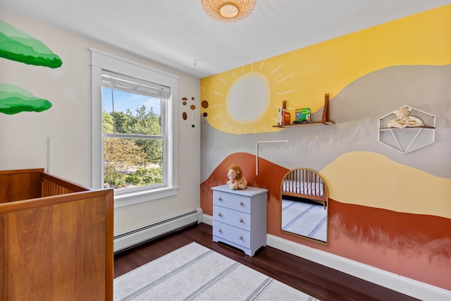 bedroom with a nursery area, wood finished floors, and a baseboard radiator