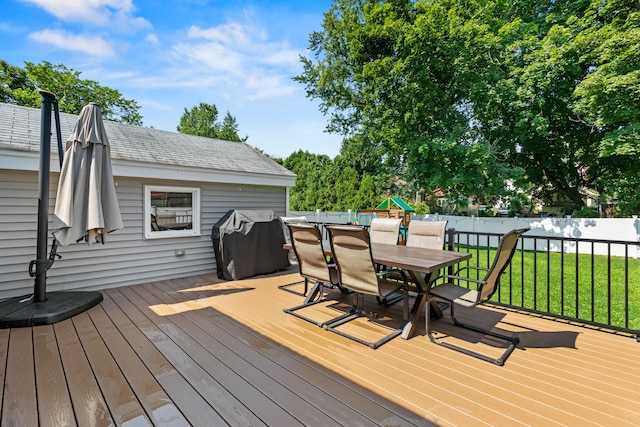 deck featuring fence, outdoor dining area, and a lawn
