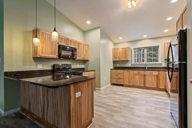 kitchen featuring a sink, black appliances, light wood-style flooring, a peninsula, and baseboards