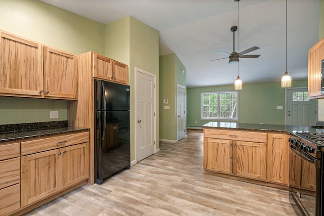 kitchen with dark stone counters, black appliances, light wood-type flooring, a ceiling fan, and lofted ceiling