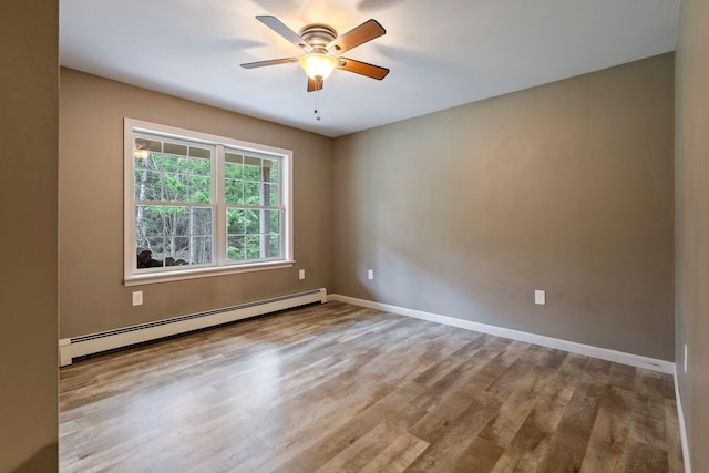 unfurnished room featuring a baseboard heating unit, a ceiling fan, wood finished floors, and baseboards