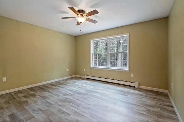 unfurnished room with baseboard heating, baseboards, wood finished floors, and a ceiling fan