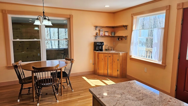 dining space featuring baseboards, light wood-style flooring, and plenty of natural light