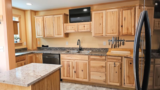 kitchen with black appliances, light brown cabinetry, and a sink