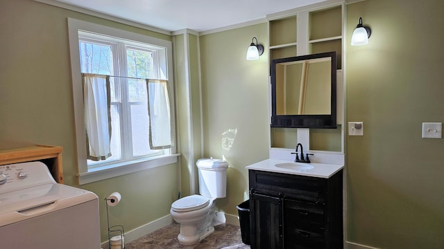 half bath featuring vanity, toilet, washer / clothes dryer, and baseboards