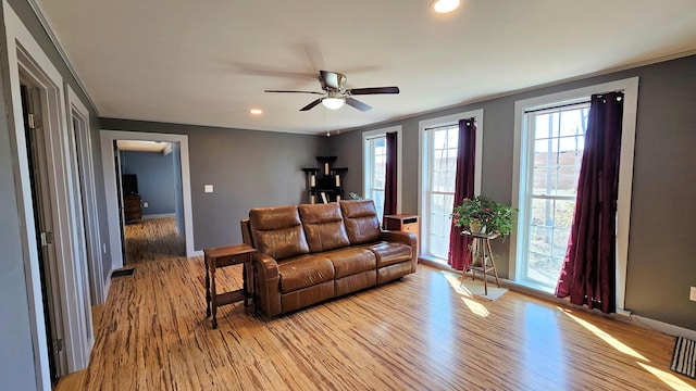 living room with recessed lighting, a ceiling fan, baseboards, and light wood-type flooring