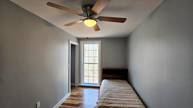 bedroom featuring dark wood-type flooring, a ceiling fan, and baseboards
