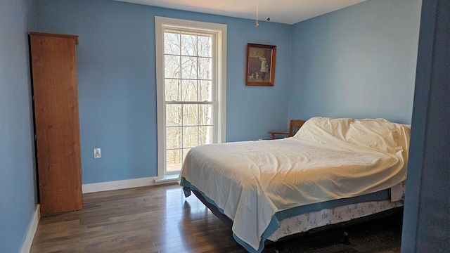 bedroom featuring wood finished floors and baseboards