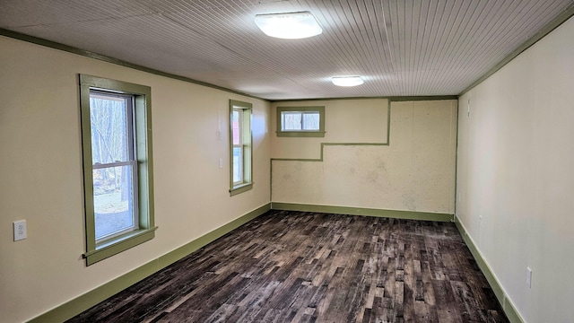 empty room with dark wood-style flooring and baseboards