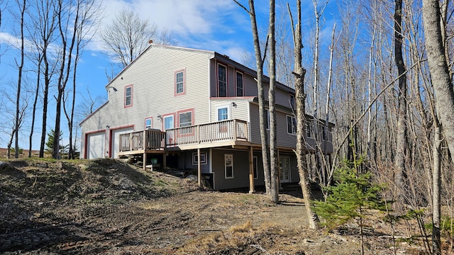 rear view of house with a garage and a wooden deck