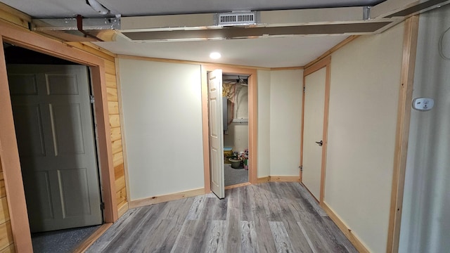 finished basement with wood finished floors, visible vents, and baseboards