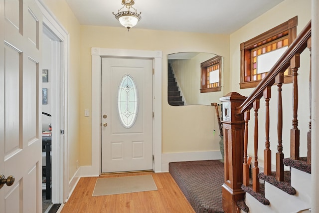 126 Elm St, Newport, ME 04953 - foyer with baseboards, stairway, wood finished floors, and arched walkways