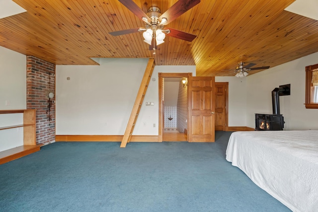bedroom featuring a wood stove, wood ceiling, ceiling fan, and carpet flooring