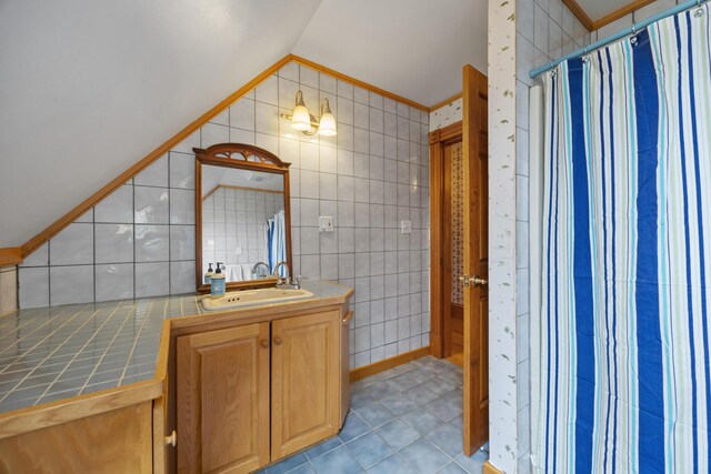 full bathroom with crown molding, tile patterned flooring, vaulted ceiling, curtained shower, and vanity