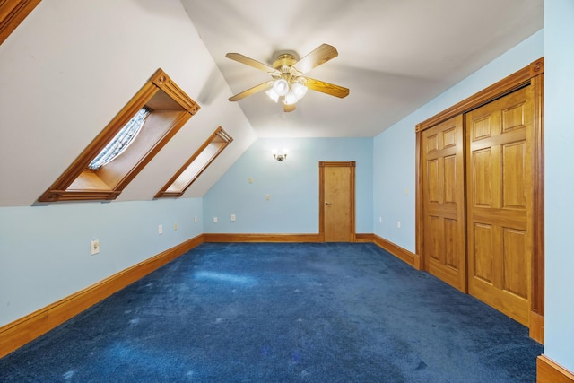 additional living space featuring baseboards, a ceiling fan, lofted ceiling with skylight, and carpet flooring