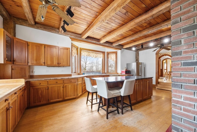 kitchen with wooden ceiling, ceiling fan, freestanding refrigerator, and beam ceiling
