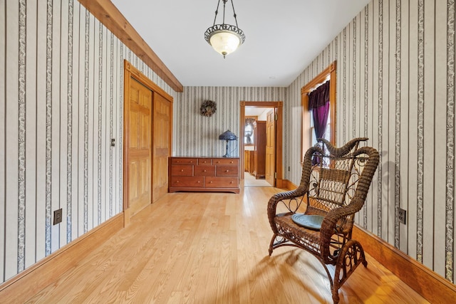 sitting room featuring wallpapered walls and wood finished floors