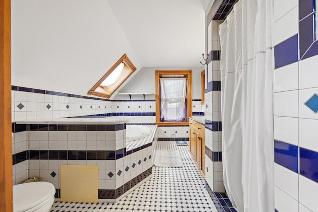 bathroom featuring tiled tub, tile patterned floors, toilet, and tile walls