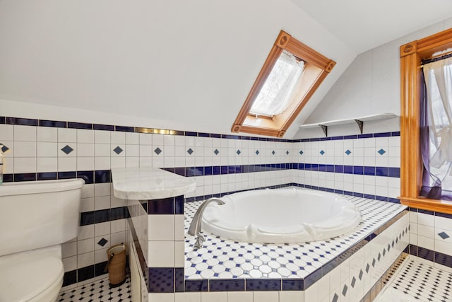 bathroom featuring a garden tub, lofted ceiling with skylight, tile patterned floors, and tile walls